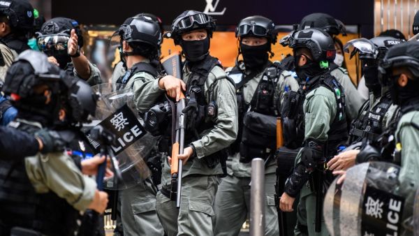 Riot police take part in a crowd dispersal operation in the Central district of Hong Kong on May 27, 2020, as the city's legislature debates over a law that bans insulting China's national anthem. Hong Kong police cast a dragnet around the financial hub's legislature on Wednesday, firing pepper-ball rounds and arresting hundreds as they stamped down on protests against a bill banning insults to China's national anthem. ANTHONY WALLACE / AFP