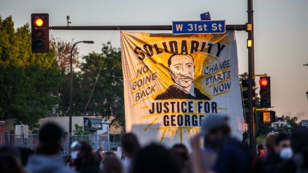 A banner depicting George Floyd is hanged to a street light during a demonstration to call for justice for George Floyd, a black man who died while in custody of the Minneapolis police, on May 30, 2020 in Minneapolis, Minnesota. (DELIL SOULEIMAN / AFP) A banner depicting George Floyd is hanged to a street light during a demonstration to call for justice for George Floyd, a black man who died while in custody of the Minneapolis police, on May 30, 2020 in Minneapolis, Minnesota. (DELIL SOULEIMAN / AFP)