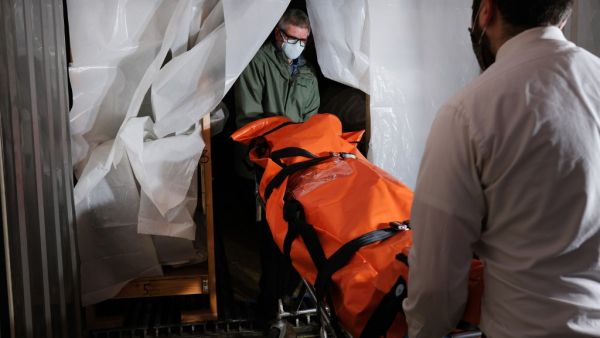 The body of a coronavirus victim is transported to a refrigerated container at a funeral home in Queens on April 29, 2020 in New York City. The funeral home, which serves a busy and diverse community in Queens, has been overwhelmed with the deceased from COVID-19. (AFP/File)