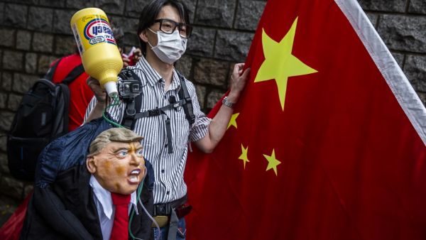 A pro-China activist holds an effigy of US President Donald Trump during a protest outside the US consulate in Hong Kong on May 30, 2020, in response to US President Donald Trump saying on May 29 he would strip several of Hong Kong's special privileges with the United States and bar some Chinese students from US universities in anger over Beijing's bid to exert control in the financial hub. ISAAC LAWRENCE / AFP A pro-China activist holds an effigy of US President Donald Trump during a protest outside the US consulate in Hong Kong on May 30, 2020, in response to US President Donald Trump saying on May 29 he would strip several of Hong Kong's special privileges with the United States and bar some Chinese students from US universities in anger over Beijing's bid to exert control in the financial hub. ISAAC LAWRENCE / AFP
