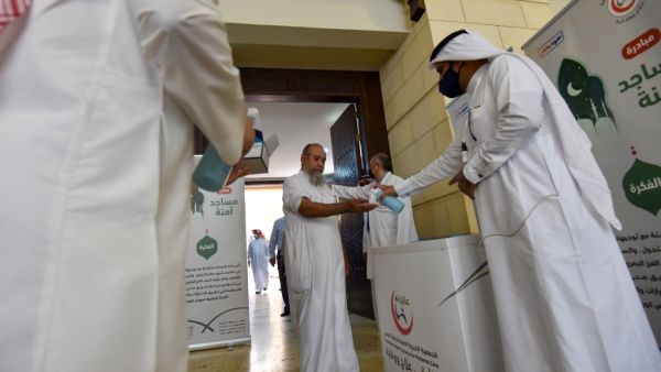A Saudi medical worker sanitises the hands of a worshipper upon his arrival to perform noon prayer at Al-Rajhi mosque in the capital Riyadh on May 31 ,2020, after authorities eased lockdown measures for prayers in mosques. FAYEZ NURELDINE / AFP