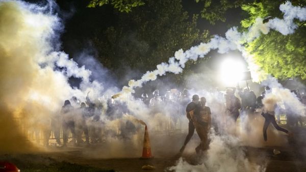 Tear gas rises above as protesters face off with police during a demonstration outside the White House over the death of George Floyd at the hands of Minneapolis Police in Washington, DC, on May 31, 2020. Thousands of National Guard troops patrolled major US cities after five consecutive nights of protests over racism and police brutality that boiled over into arson and looting, sending shock waves through the country. The death Monday of an unarmed black man, George Floyd, at the hands of police in Minneap