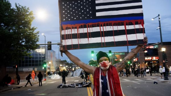 A demonstrator holds up a sign during a protest in Denver, Colorado, on May 31, 2020, over the death of George Floyd, an unarmed black man who died while while being arrested and pinned to the ground by the knee of a Minneapolis police officer. Thousands of National Guard troops patrolled major US cities after five consecutive nights of protests over racism and police brutality that boiled over into arson and looting, sending shock waves through the country. The death Monday of an unarmed black man, George 