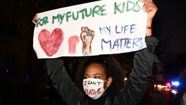 A protesters holds a banner and shout slogans during a rally for justice in Sydney on June 2, 2020, against the deaths of members of the Aboriginal community in Australia and the death of George Floyd, an unarmed black man who died in police custody in the US city of Minneapolis which has sparked violent protests across the US. PETER PARKS / AFP