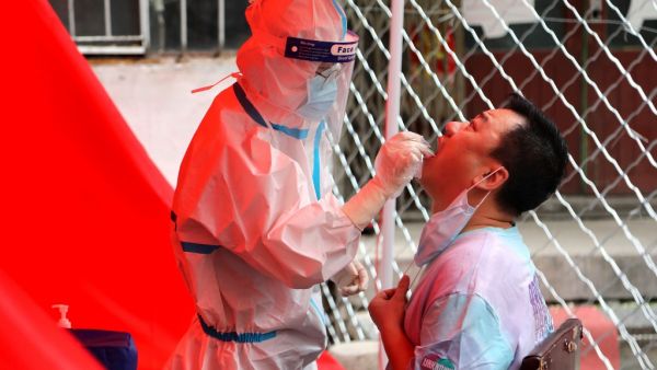 A medical worker takes a swab sample from a resident to be tested for the COVID-19 coronavirus on a street in Mudanjiang, China’s northeastern Heilongjiang province on June 3, 2020. COVID-19 coronavirus testing were made available for free to Heilongjiang province residence starting from June 1, for a week. STR / AFP