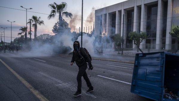 A protester walks among tear gas during clashes in a demonstration outside the U.S. embassy in Athens, on June 3, 2020, after George Floyd, an unarmed black man died after a police officer knelt on his neck during an arrest in Minneapolis, USA. Angelos Tzortzinis / AFP
