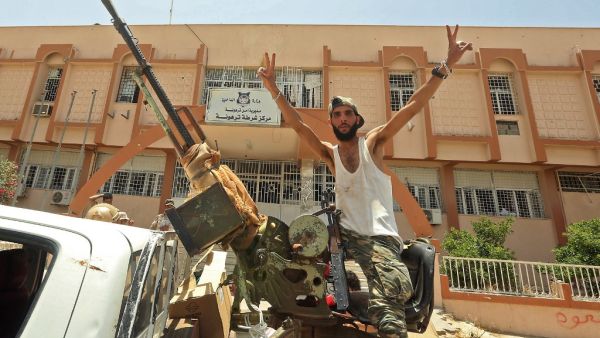 A fighter loyal to Libya's UN-recognised Government of National Accord (GNA) poses for a picture while seated in the turret a technical (pickup truck mounted with turret) in the town of Tarhuna, about 65 kilometres southeast of the capital Tripoli on June 5, 2020, after the area was taken over by pro-GNA forces from rival forces loyal to strongman Khalifa Haftar. Mahmud TURKIA / AFP