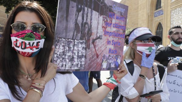 Mask-clad Lebanese protesters take part in a demonstration in central Beirut, on June 6, 2020. Protesters poured into the streets of the Lebanese capital to decry the collapse of the economy, as clashes erupted between supporters and opponents of the Iran-backed Shiite group Hezbollah. ANWAR AMRO / AFP