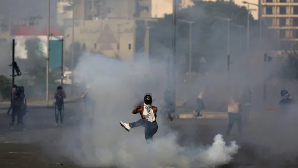 A Lebanese protester kicks a tear gas canister amid clashes with riot police following a demonstration in central Beirut, on June 6, 2020. Protesters poured into the streets of the Lebanese capital to decry the collapse of the economy, as clashes erupted between supporters and opponents of the Iran-backed Shiite group Hezbollah. PATRICK BAZ / AFP