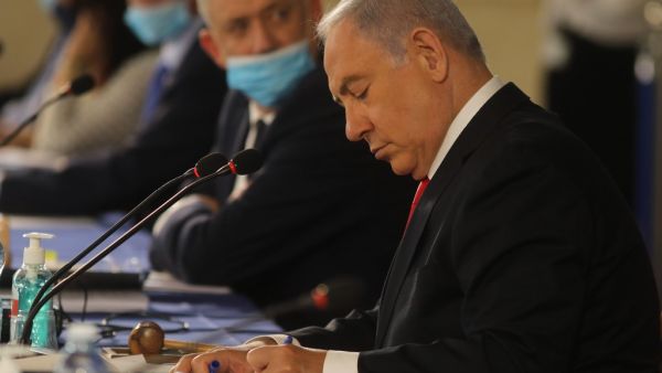 Israeli Prime Minister Benjamin Netanyahu writes during the weekly cabinet meeting in Jerusalem on June 7, 2020. Netanyahu urged world powers to reimpose tough sanctions against Iran, vowing to curb Tehran's regional "aggression" hours after another deadly strike on pro-Iranian fighters in Syria. Menahem KAHANA / AFP