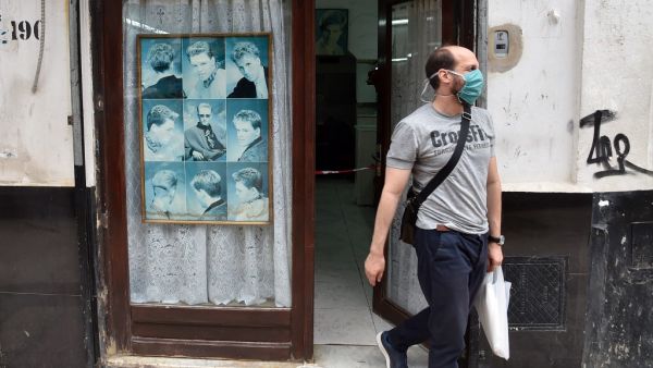 An Algerian man leaves a barber shop after getting a haircut in the capital Algiers on June 7, 2020, after authorities eased some restrictions put in place in a bid to fight the spread of the novel coronavirus. RYAD KRAMDI / AFP