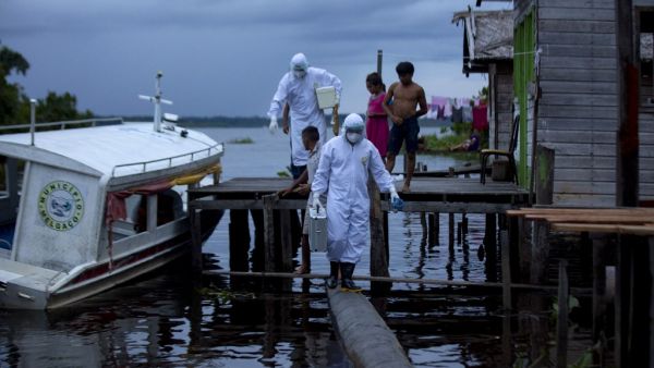 Health workers from the city of Melgaco arrive to a small riverside community at the Quara river, where eight families live without electricity, to give medical care to its residents amid concern over the spread of the COVID-19 coronavirus, in the southwest of Marajo Island, state of Para, Brazil, on June 9, 2020. TARSO SARRAF / AFP