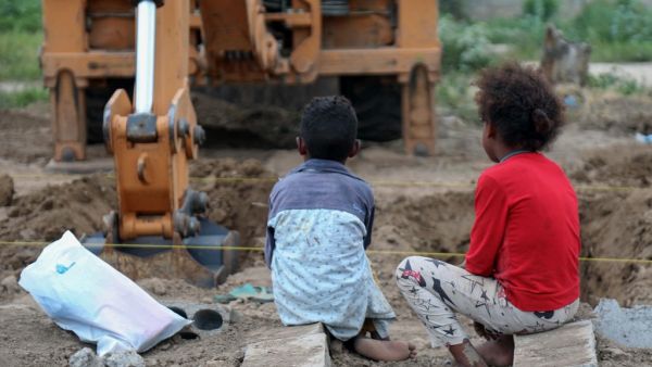 Yemeni children watch as an excavator digs graves at a specific plot for COVID-19 victims, at a cemetery in Yemen's third city of Taez, on June 14, 2020. Ahmad AL-BASHA / AFP