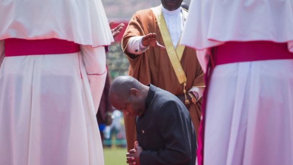 Burundi's elected President Evariste Ndayishimiye (C) prays on his knees with Burundi's religious leaders during the inauguration ceremony at Ingoma stadium in Gitega, Burundi, on June 18, 2020. Ndayishimiye rapidly sworn in following the sudden death of President Pierre Nkurunziza, aged 55, came after the May election. TCHANDROU NITANGA / AFP