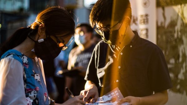 Pro-democracy activist Joshua Wong (R) stands next to a supporter after he announced his plan to run for the upcoming Legislative Council elections in Hong Kong on June 19, 2020. Anthony WALLACE / AFP