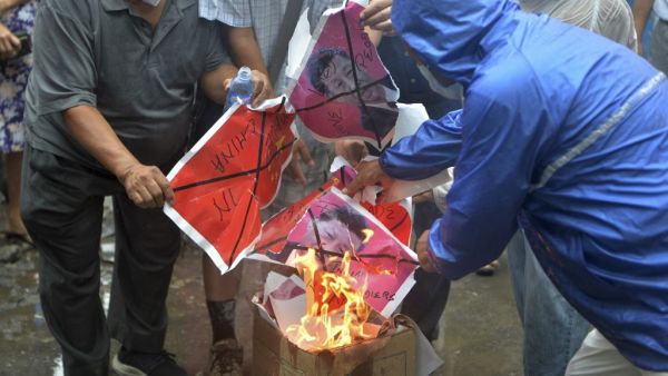 Indian activists along with Tibetans living in exile shout anti Chinese slogans as they burn Chinese flags and poster depicting Chinese President Xi Jinping during an anti-China demonstration in Siliguri on June 20, 2020. Diptendu DUTTA / AFP