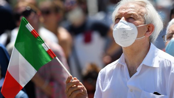 A man wearing a face mask and holding the Italian flag attends the Pope's weekly Angelus prayer at St. Peter's Square in The Vatican, on June 28, 2020 as the city-state eases its lockdown aimed at curbing the spread of the COVID-19 infection, caused by the novel coronavirus. Alberto PIZZOLI / AFP