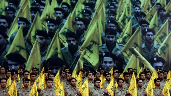Members of Hezbollah's armed wing stand to attention as hundreds of people gather to watch a televised speech by Hassan Nasrallah on February 22, 2008, in Beirut, Lebanon. [JOSEPH BARRAK/AFP via Getty Images]