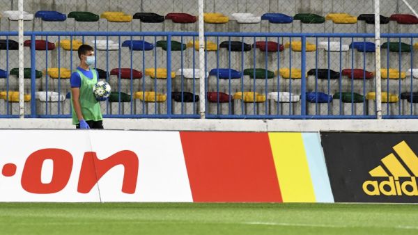 A ball boy wearing a protective mask stands in front of empty grandstand during the football match between FC Lokomotiva and FC Osijek in Zagreb.