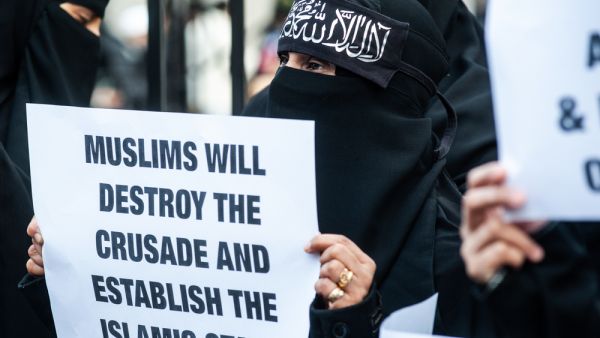 A woman holds a placard reading "Muslims will destroy the crusade and estabilish the Islamic State!" outside the Regents Park Mosque. (Shutterstock/ File Photo)