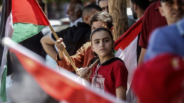 Palestinian children carry national flags as they take part in a protest against Israel's plans to annex parts of the occupied West Bank, in Rafah in the southern Gaza Strip on June 27, 2020. Israel aims to begin a process of annexing West Bank settlements and the Jordan Valley from July 1. SAID KHATIB / AFP