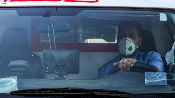 A mask-clad driver sits behind the wheel in an ambulance in the central Karrada district of Iraq's capital Baghdad on July 1, 2020. AFP