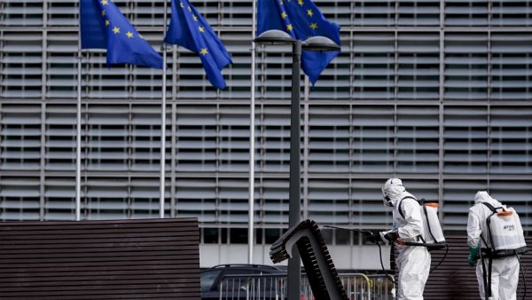 Men disinfect benches in Brussels on July 10, 2020 in front of the European institutions. Kenzo TRIBOUILLARD / AFP