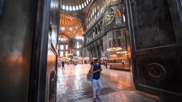 A woman walk through the huge doors of the Hagia Sophia museum in Istanbul, on July 10, 2020. Turkish President Recep Tayyip Erdogan announced on July 10, 2020 that the Hagia Sophia, one of the architectural wonders of the world, would be reopened for Muslim worship, sparking fury among Christian leaders and in neighbouring Greece. Ozan KOSE / AFP