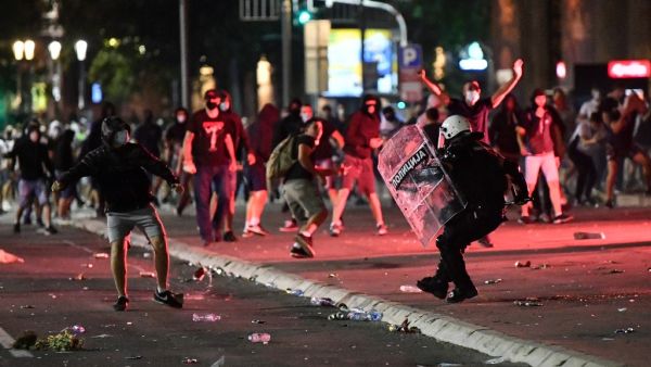 A police officer clashes with protesters near the National Assembly building in Belgrade, on July 10, 2020, during a demonstration against a weekend curfew announced to combat a resurgence of COVID-19 (novel coronavirus) infections. Serbia announced a record coronavirus death toll for a single day on July 10, as the government hit back at protests over its handling of the pandemic. ANDREJ ISAKOVIC / AFP