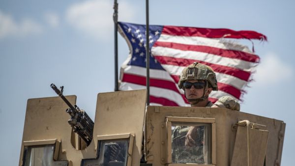 A US soldier sits atop a vehicle in a convoy patrolling an area in the countryside of Tal Tamr town, in Syria's northeastern Hasakeh province near the border with Turkey, on July 11, 2020. Delil SOULEIMAN / AFP