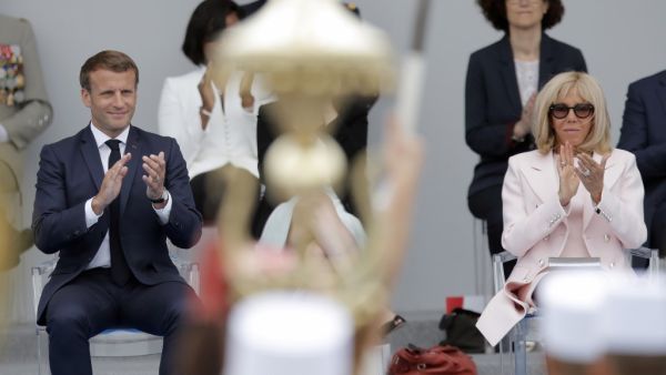 French President Emmanuel Macron (L) and his wife Brigitte Macron applaud during the annual Bastille Day military ceremony on the Place de la Concorde in Paris, on July 14, 2020. France holds a reduced version of its traditional Bastille Day parade this year due to safety measures over the COVID-19 (novel coronavirus) pandemic, and with the country's national day celebrations including a homage to health workers and others fighting the outbreak. Christophe Ena / POOL / AFP