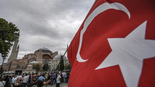 A man waves a Turkish national flag at the square of Hagia Sophia during the fourth anniversary of the failed coup attempt in Istanbul on July 15, 2020. Ozan KOSE / AFP