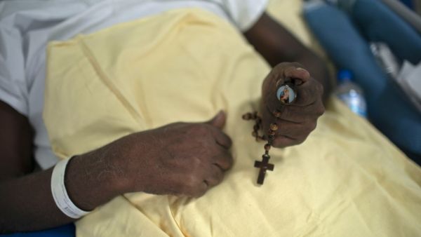 A COVID-19 patient holds a rosary at the post-COVID-19 ward of the Pedro Ernesto University Hospital (HUPE) in Rio de Janeiro, Brazil, on July 15, 2020, amid the novel coronavirus pandemic. The ward treats patients facing economic and social lacks that affect their capacity to keep proper medical care of their several health complications caused by COVID-19 and other diseases. Mauro PIMENTEL / AFP