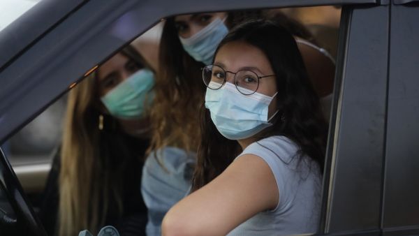 Lebanese women wearing protective masks amid the COVID-19 pandemic wait in their car to watch a movie at a drive-in cinema at a park in the coastal town of Byblos, north of the capital on July 18, 2020. JOSEPH EID / AFP