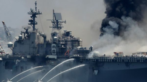 A fire burns on the amphibious assault ship USS Bonhomme Richard at Naval Base San Diego on July 12, 2020 in San Diego, California. There was an explosion on board the ship with multiple injuries reported. Sean M. Haffey/Getty Images/AFP Sean M. Haffey / GETTY IMAGES NORTH AMERICA / Getty Images via AFP