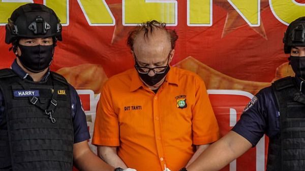 Indonesia police wearing  face masks and protective gloves guard the Frenchman Francois Abello Camille during a press conference in Jakarta. (AFP)