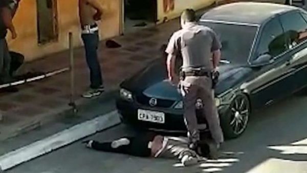 A brazilian cop standing on a black woman's neck (Twitter)
