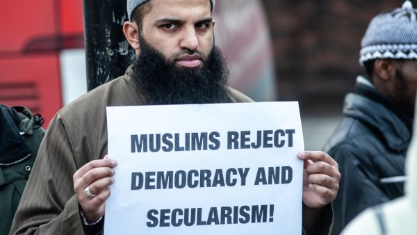 London, UK - 24 January 2014: a protester holds a placard reading "Muslims reject democracy and secularism!" outside the Regents Park Mosque  (Shutterstock)