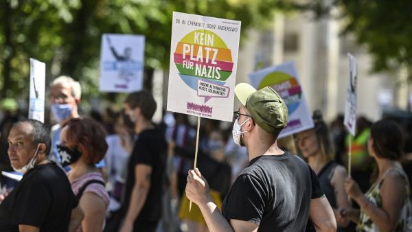 A counter-protester holds a sign reading "No place for Nazis" during a demonstration by the initiative "Querdenken-711" with the slogan "the end of the pandemic-the day of freedom" to protest against the current measurements to curb the COVID-19 spreading in Berlin, on August 1, 2020. John MACDOUGALL / AFP