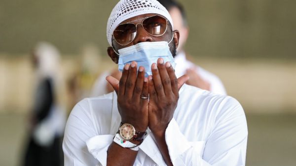 A Muslim pilgrim, clad in a face mask due to the COVID-19 coronavirus pandemic, prays after throwing pebbles as part of the symbolic al-A'qabah (stoning of the devil ritual) at the Jamarat Bridge during the Hajj pilgrimage in Mina, near Saudi Arabia's holy city of Mecca, on August 2, 2020. Massive crowds in previous years triggered deadly stampedes during the ritual, but this year only up to 10,000 Muslims are taking part after millions of international pilgrims were barred because of the covid-19 pandemic 