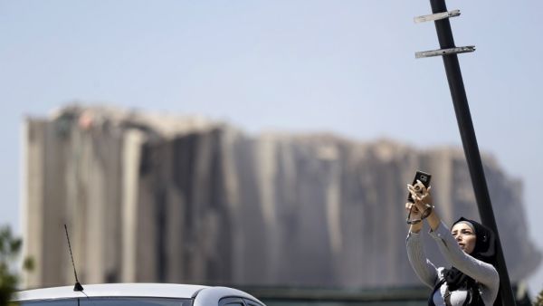 A woman takes a selfie near Beirut port on August 5, 2020 in the aftermath of a massive explosion in the Lebanese capital Beirut. Rescuers searched for survivors in Beirut after a cataclysmic explosion at the port sowed devastation across entire neighbourhoods, killing more than 100 people, wounding thousands and plunging Lebanon deeper into crisis. The blast, which appeared to have been caused by a fire igniting 2,750 tonnes of ammonium nitrate left unsecured in a warehouse, was felt as far away as Cyprus,