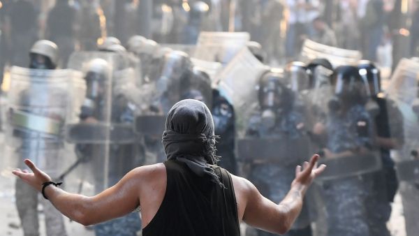 A Lebanese protester gestures towards security forces during clashes in downtown Beirut on August 8, 2020, following a demonstration against a political leadership they blame for a monster explosion that killed more than 150 people and disfigured the capital Beirut. AFP A Lebanese protester gestures towards security forces during clashes in downtown Beirut on August 8, 2020, following a demonstration against a political leadership they blame for a monster explosion that killed more than 150 people and disfigured the capital Beirut. AFP