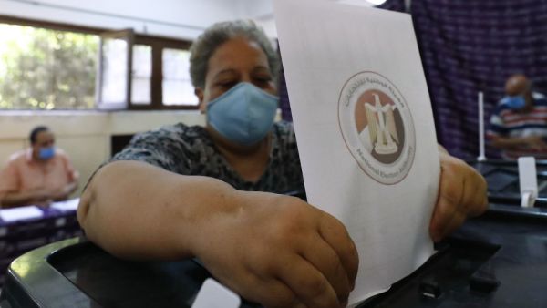 An Egyptian woman, mask-clad due to the COVID-19 coronavirus pandemic, casts her vote at polling station on August 11, 2020 for a new senate in an upper house election. The two-day vote for 200 of the Senate's 300 seats will be largely contested by candidates who back President Abdel Fattah al-Sisi, who has quietened most opposition within and outside the legislature.  Khaled DESOUKI / AFP