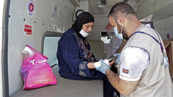 Medics working at a mobile clinic held jointly by Lebanese NGO Amel Association International and Medecins du Monde (MDM) provide medical care on August 11, 2020 to the residents of Beirut's badly-damaged Karantina district following the earth-shaking explosion which killed more than 170 people and wounded more than 6,000 in the Lebanese capital on August 4. Volunteers of Amel Association International, a local charity founded during the 1975-1990 civil war, and MDM or Doctors of the World, an international