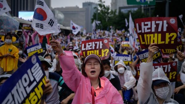 Members of pro-US conservative right-wing and religious christian groups wave flags and shout slogans during an anti-government rally in the central Gwanghwamun area of Seoul on August 15, 2020. (AFP)