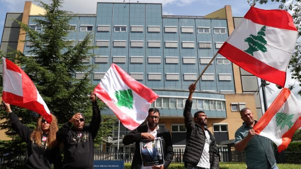 People gather and wave Lebanon national flags in front of the UN-backed Special Tribunal for Lebanon (STL) at Leidschendam on August 18, 2020, before the expected verdict on the 2005 murder of his father former Lebanese premier Rafic Hariri. (AFP/ File)