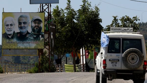 A UNIFIL patrol drives past a billboard showing the faces of slain (L ro R) Iraqi Hashed al-Shaabi (Popular Mobilisation) forces commander Abu Mahdi al-Muhandis, Iranian Quds Force commander Qasem Soleimani, and Hezbollah commander Imad Mughniyeh, in the southern Lebanese village of Adaisseh on the border with Israel on August 26, 2020. (AFP)