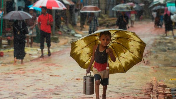 A Rohingya refugee boy shelters under an umbrella as he makes his way during a monsoon rainfall at Kutupalong refugee camp in Ukhia on Sept. 12, 2019. (AFP Photo)