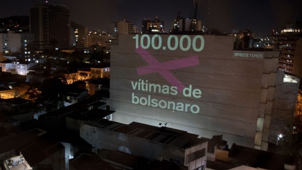 A projection on a building honouring the 100,000 victims who died of the novel coronavirus COVID-19 in Brazil reads "100,000 Victims of (Brazilian President Jair) Bolsonaro" as the country became the second in the world to pass the grim milestone, in Botafogo neighbourhood in Rio de Janeiro, Brazil, on August 8, 2020. Mauro PIMENTEL / AFP