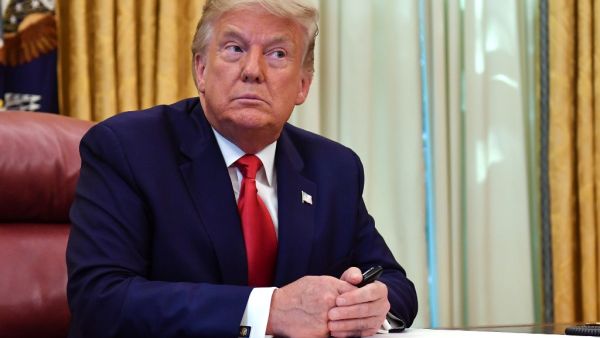 US President Donald Trump looks on before signing the pardon for Alice Johnson, in the Oval Office of the White House in Washington, DC, on August 28, 2020. Trump granted Johnson, a criminal justice reform advocate and former federal prisoner, a full pardon after commuting her sentence in 2018. NICHOLAS KAMM / AFP